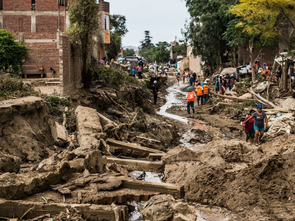 Neighbourhood street covered in mud and debris during flood aftermath cleanup